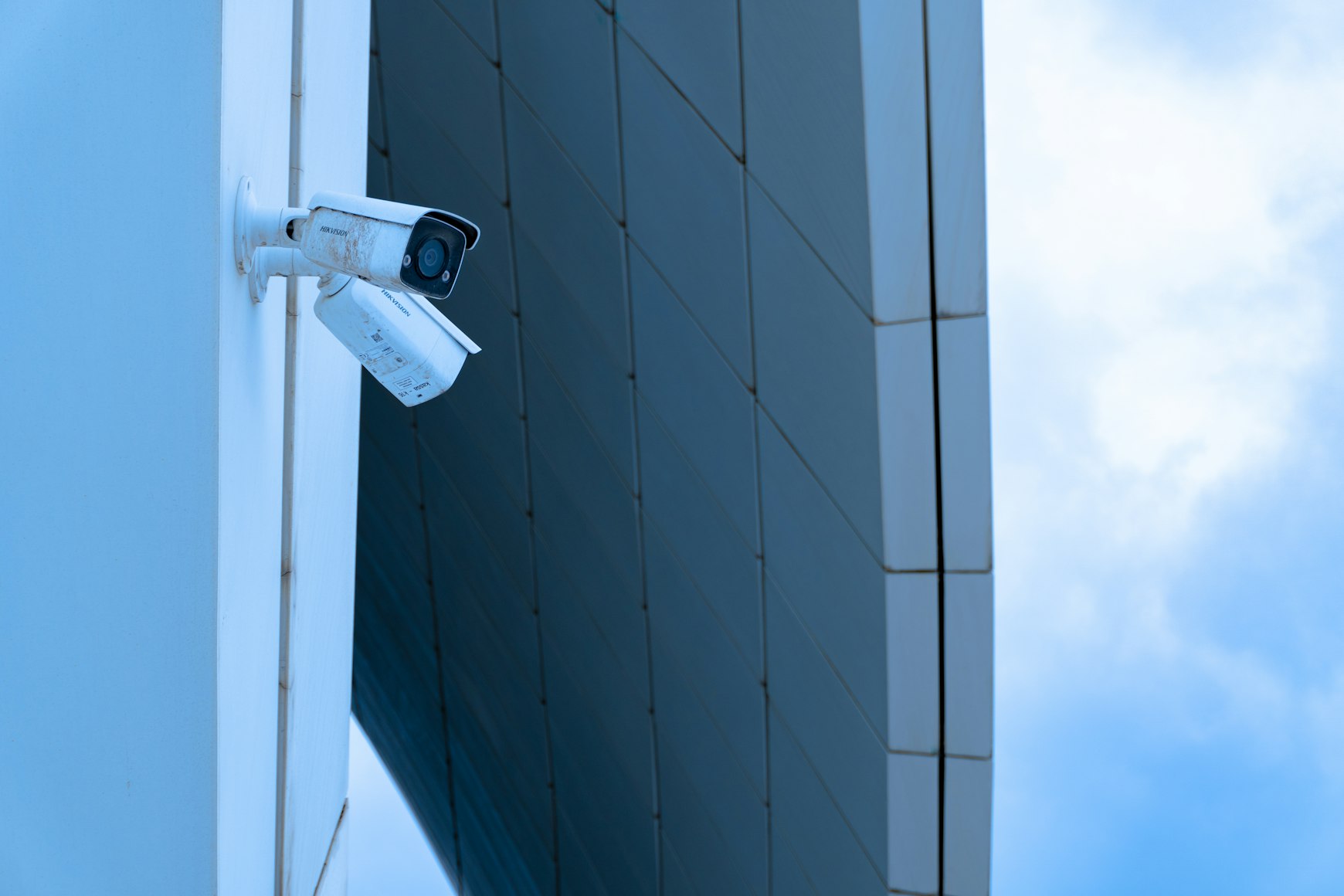 Real CCTV cameras mounted on the exterior wall of a commercial building.